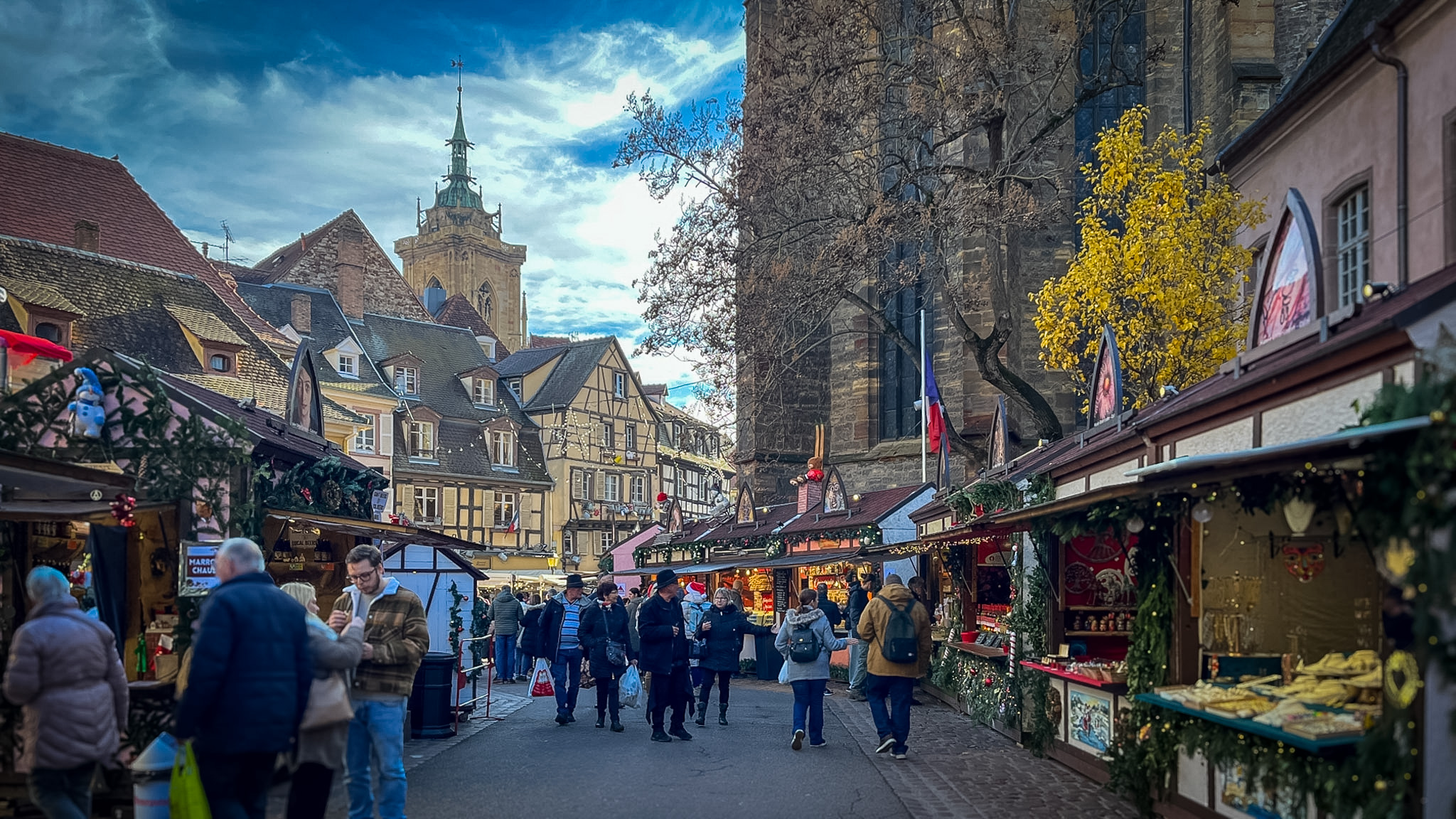 Mercado de Navidad en la Place des Dominicains de Colmar con la iglesia gótica iluminada de noche